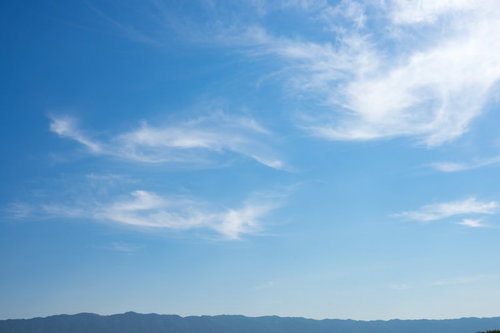 山沿いに一時的に晴れ渡った空と白い雲