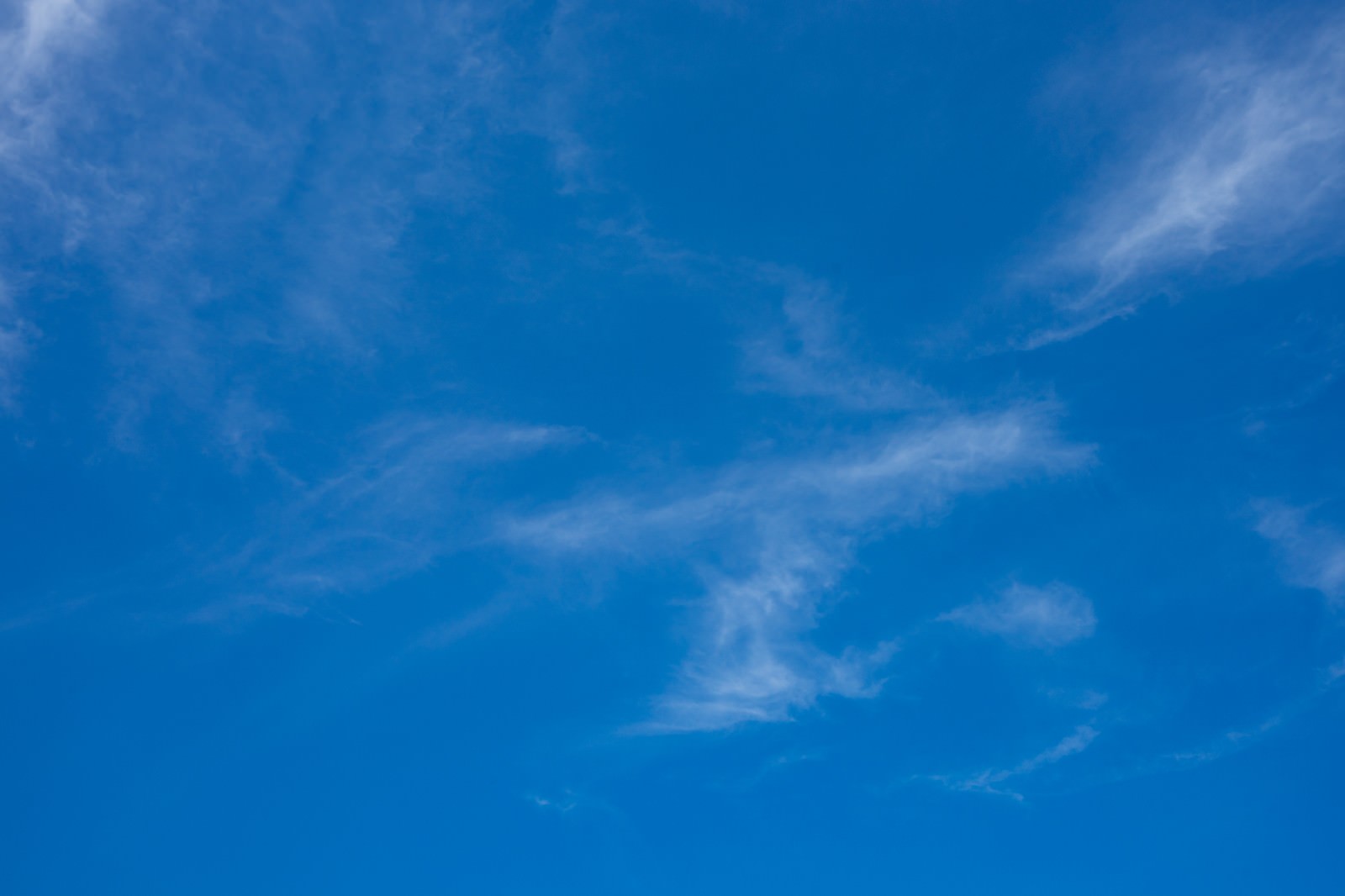 青空に白い雲が点在する晴れた昼間の空