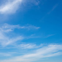 真っ青な快晴の空に浮かぶ薄い白い雲が流れる風景の写真