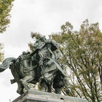 大刀洗公園の菊池武光像と秋の樹林・福岡の歴史的銅像の写真