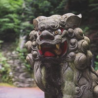 苔むした狛犬：神社参道の歴史的石造彫刻と門番像の写真