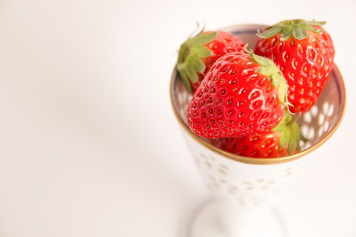 籠入りカップに盛られた新鮮な苺のデザートの写真