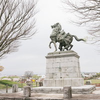 大刀洗公園に立つ菊池武光騎馬像と春の満開桜の写真