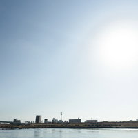 河川敷から見た工業地帯の街並みの写真