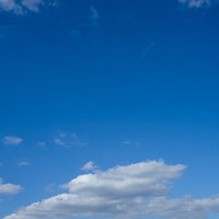 真っ青に晴れた空に浮かぶ白い積雲と雲の風景の写真