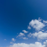 真っ青な快晴の空に浮かぶ白い積雲と筋状の雲の写真