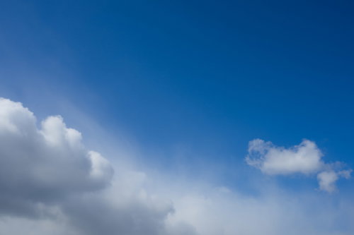 晴れた青空と白い雨雲が対比する天気の風景