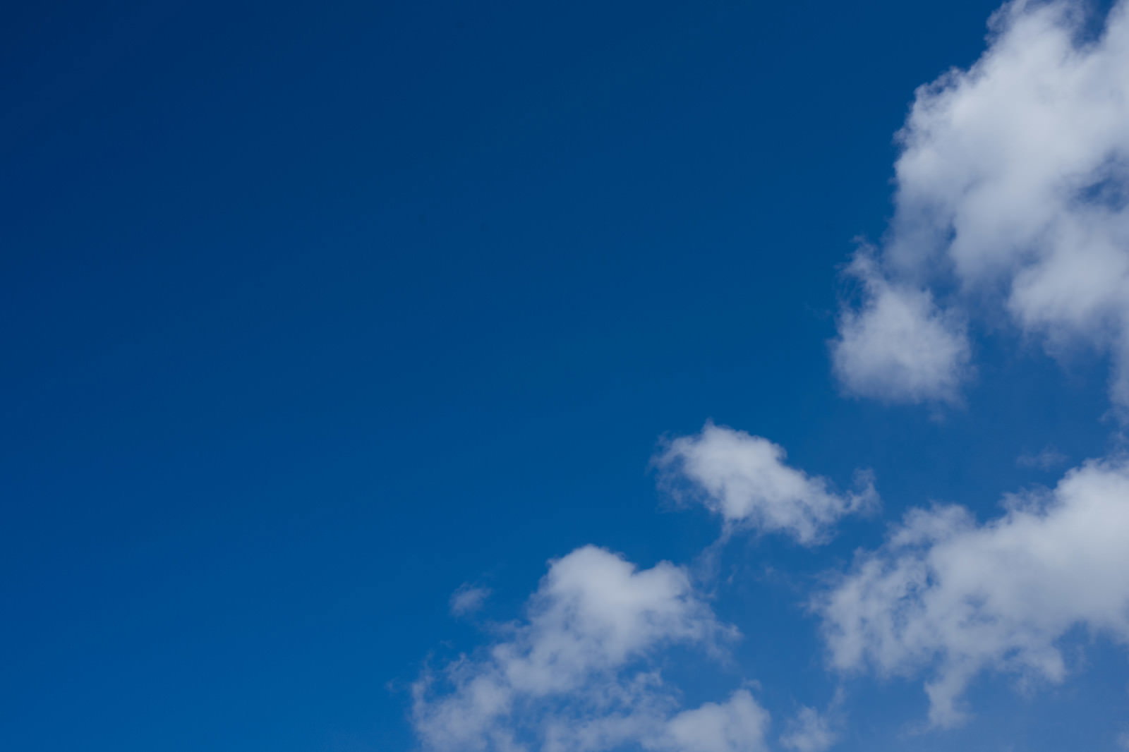 青空に白い雲がまばらに浮かぶ昼間の空