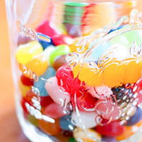 小瓶に入ったカラフルなジェリービーンズの瓶詰めの写真