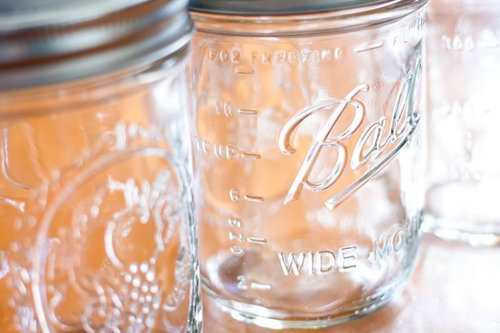 ガラス瓶に入った琥珀色の液体とメイソンジャーの