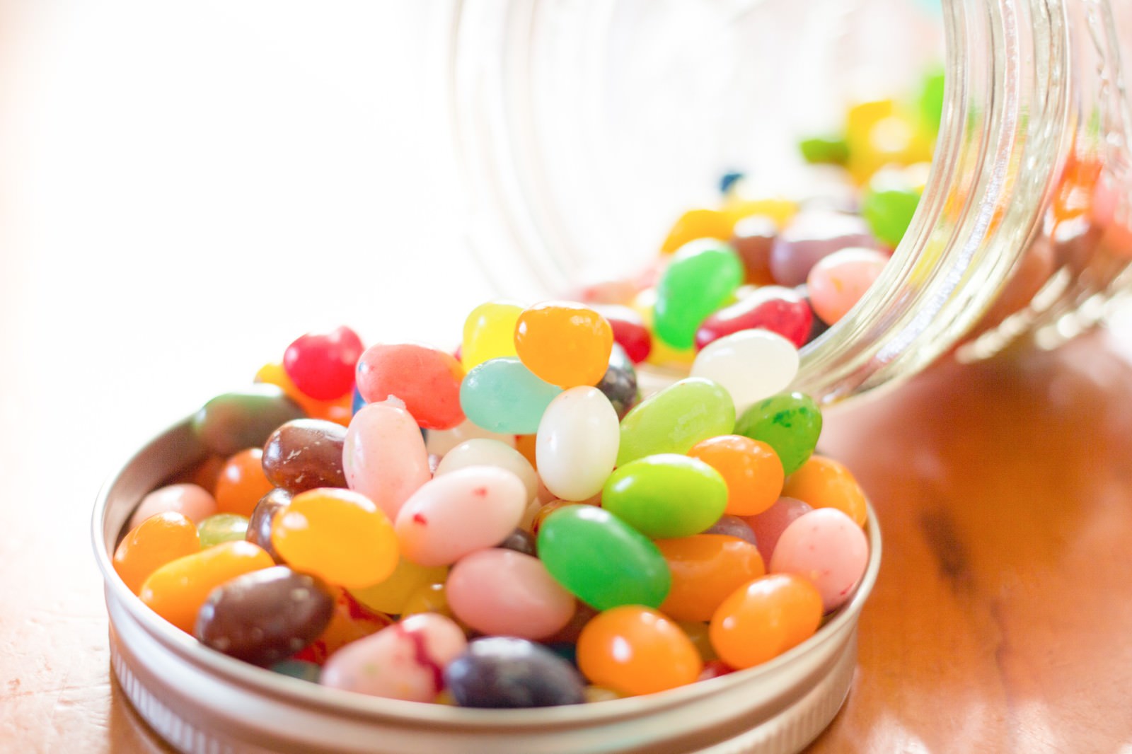 瓶からこぼれ出すカラフルなジェリービーンズ