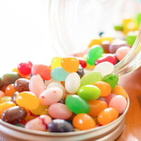 瓶から溢れ出すカラフルなジェリービーンズの写真