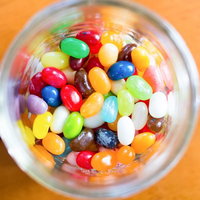 ガラス瓶に詰まったカラフルな飴のビーンズの写真
