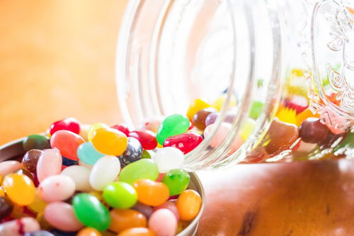 瓶から溢れだしたカラフルなジェリービーンズとキャンディ