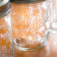 テーブルに並べられた計量目盛り付きの空き瓶の写真