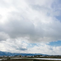 大刀洗の街並みと冬の曇り空、水田と山並みの郊外風景の写真