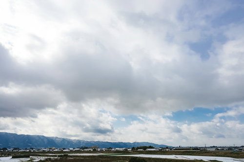 大刀洗の街並みと冬の曇り空、水田と山並みの郊外風景
