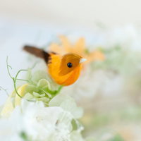 白い花に止まった黄色い小鳥の置物の写真