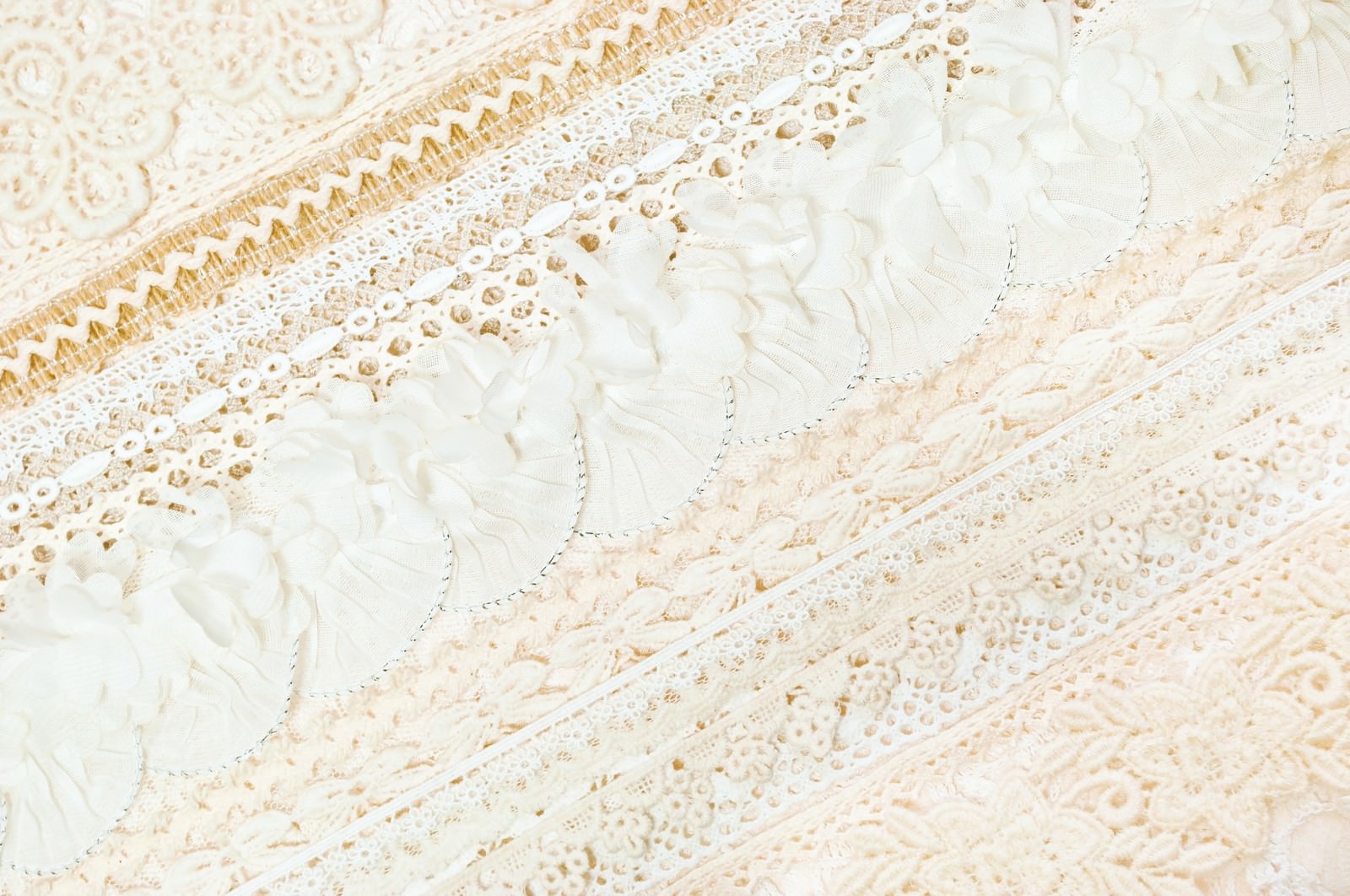 白い布の上に重なるレースとビーズ装飾のテクスチャー