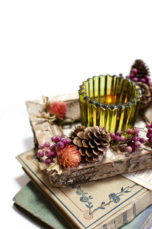 黄色いキャンドルと松ぼっくり、古い洋書で作る秋の装飾