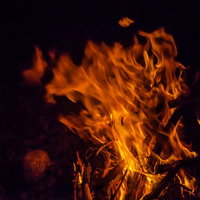 夜の闇に燃え上がる焚き火の炎の写真