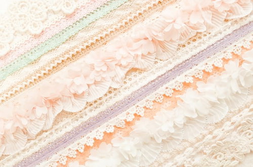 パステルカラーのレースやリボンが斜めに並ぶテクスチャー