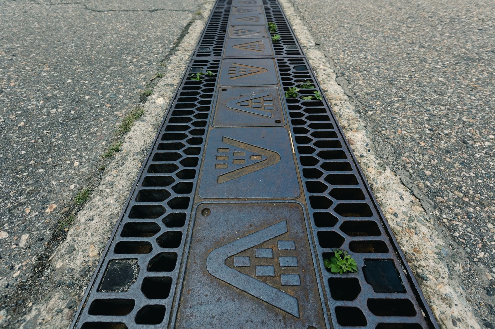 アスファルトの道路に設置された合掌造りモチーフの側溝蓋