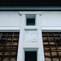 白い壁と黒い格子戸が対比する南砺市の土蔵の正面の写真