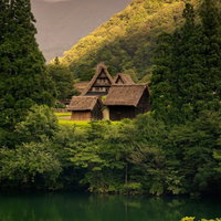 川越しに見る世界遺産の菅沼集落の合掌造りの写真