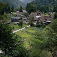 山間に佇む相倉集落の合掌造り集落と田んぼの景観の写真