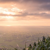雲の隙間から光が差し込む夕暮れの南砺市散居村の景観の写真