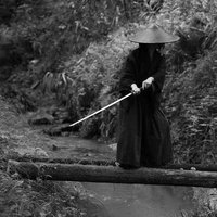 一本橋で刀を抜く隠密の武士が緊迫した表情で立つモノクロの写真