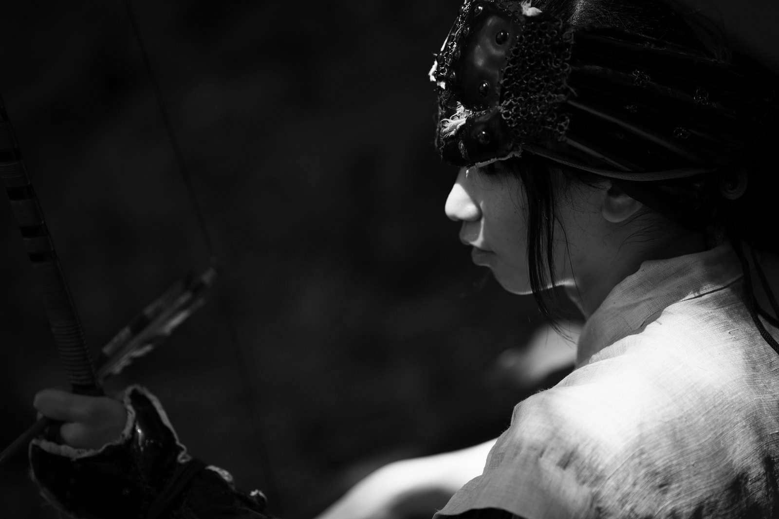 弓を構える野盗の男性の横顔を捉えたモノクロ写真［モデル：まーこ］