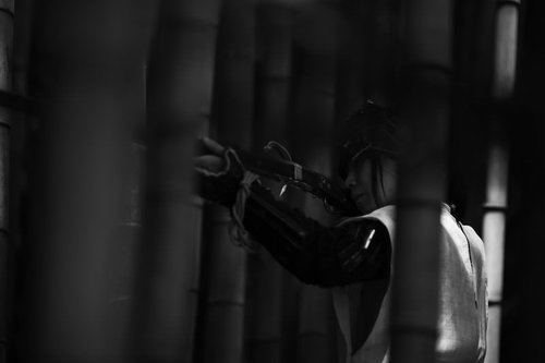 薄暗い竹林の影から火縄銃を構える野盗の緊迫した瞬間