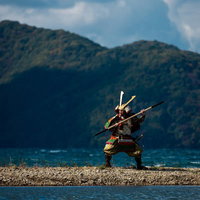 湖畔で棍棒を構える大鎧を纏う武士、山々を背景に戦闘態勢の写真