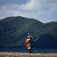 猪苗代湖の中州で棍棒を持ち構える大鎧男子の写真