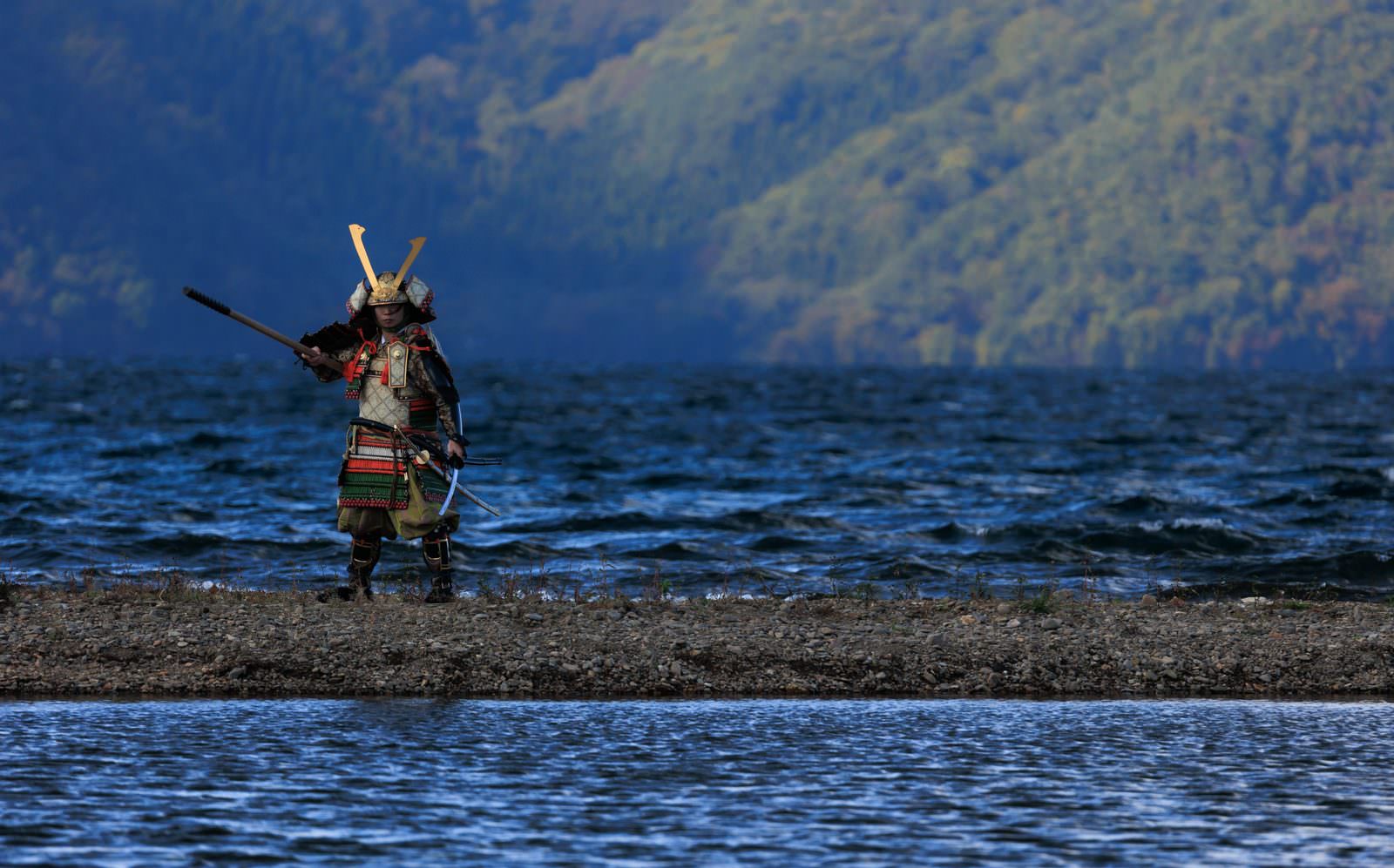 湖畔の中州で大鎧を着た侍が槍を持って立つ［モデル：まーこ］