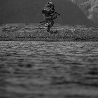 中州で刀を肩に担ぐ甲冑侍の写真