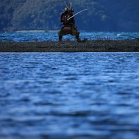 中州で対岸に向かって刀を構える大鎧で武装する侍の写真
