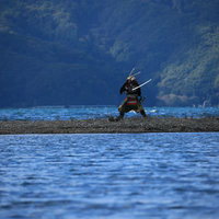 対岸を気にする大鎧で武装する侍、湖の中州で刀を構えるの写真