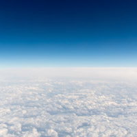上空から見た雲海と青いグラデーションの空の写真