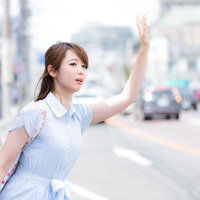 手を挙げてもタクシーがなかなか止まってくれない女性の写真