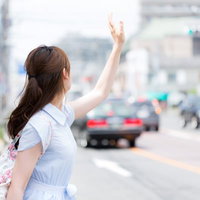 タクシーが捕まらない不幸女子、街中で手を挙げて呼び止めるの写真