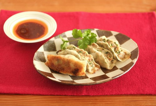 しま模様の皿に盛った餃子と味噌だれ