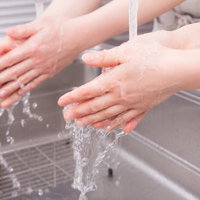 料理の前に蛇口から流水で手を洗う様子の写真