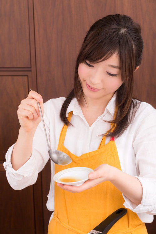 お玉でスープを味見する料理研究家