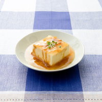 白い皿に盛られたあんかけ豆腐とネギの写真