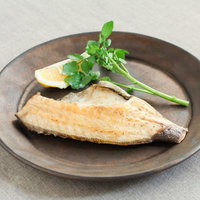 レモンを添えた焼き魚の一皿の写真
