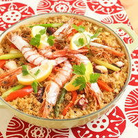 エビとレモンが乗ったパエリア鍋の写真