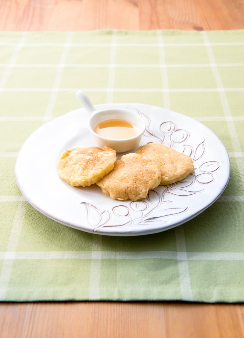 白い皿に盛り付けた豆腐のパンケーキ3枚とシロップ添え